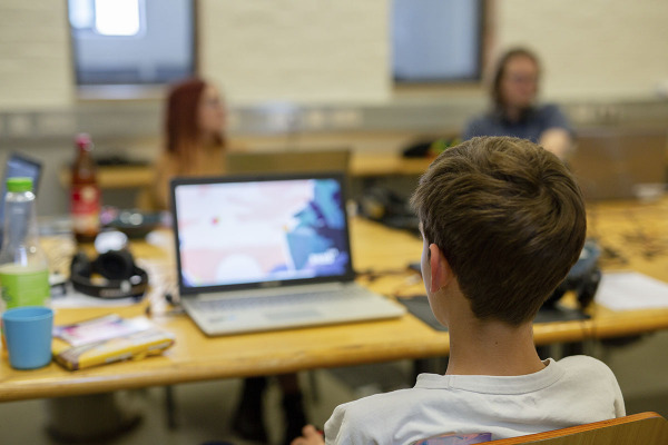 Großaufnahme eines Jugendlichen von hinten vor einem Laptop bei der Vorjurysichtung 2022
